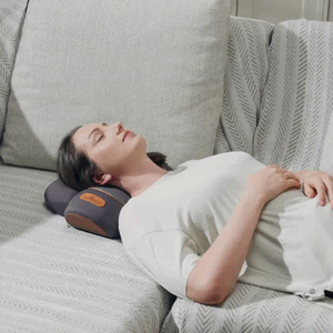 Woman relaxing on a sofa while using the NeckEase™ cervical therapy device